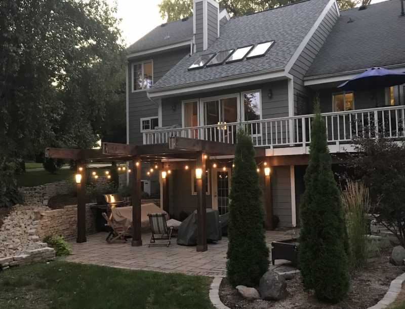 Cozy backyard with deck and string lights at dusk.
